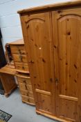 A modern pine bedroom suite comprising wardrobe, bedside chest, dressing table and mirror