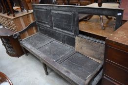 A period oak settle having panelled back and seat, width approx. 185cm