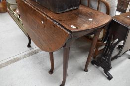 A 19th century oak drop-leaf table, with rounded oblong top above demi-lune flaps and turned
