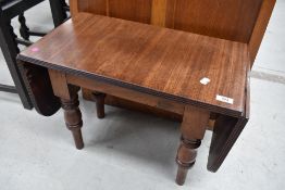 A mahogany sofa table, the oblong top with hinged rounded flaps above an associated base with turned