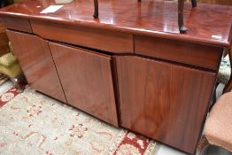 A modern stained walnut sideboard, the oblong figured top above three frieze drawers and three