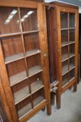 A pair of shop fitting style full height pine display cabinets/bookshelves, with central frame