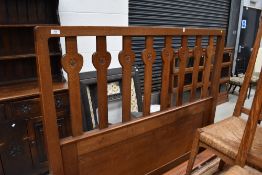 An Arts and Crafts golden oak double bed believed to be an Arthur Simpson, having heart motif rails,