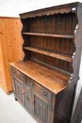 An early 20th Century oak dresser in the traditional style , having linen fold doors, and carved