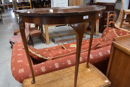 An early to mid 20th Century walnut demi lune hall table on cabriole legs