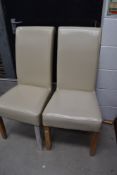 A pair of modern cream leatherette dining chairs