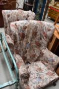 A pair of 19th century design wing back armchairs, with foliate pattered covers