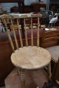 An early 20th century bleached beech bistro chair, with turned spindles and supports, repaired