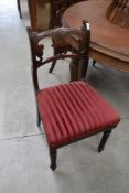 Four Regency style chairs having carved backs and legs.