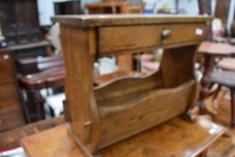 A sturdy 1930s oak magazine rack or table having trough to base and drawer to top.