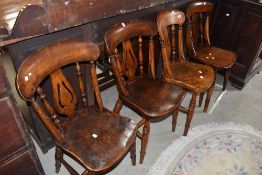 A set of four traditional solid seat kitchen dining chairs