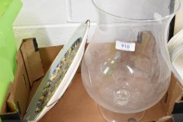 A large glass vase and ceramic charger