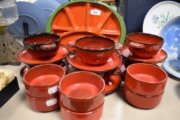 A mixed lot of ceramics, including compartmental plates in red with green edge, soup bowls and