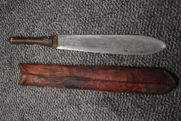 An early 20th century tribal or safari style machete knife with basic leather scabbard