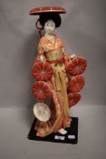 A vintage Japanese Kabuki figure study of a Geisha having porcelain body with glass eyes