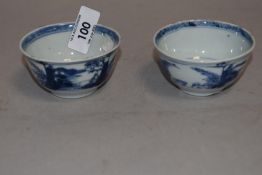 A pair of Chinese hard paste export tea bowl being hand decorated with fantasy landscape scenes