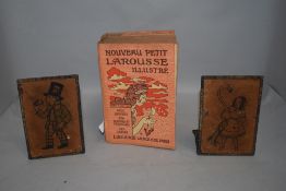 A pair of book ends with tramp style image and a copy of Nouveau Petit Larousse Illustre