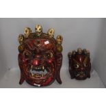 Two hand carved wooden ethic tribal or ritual masks possibly Bali or Indonesian