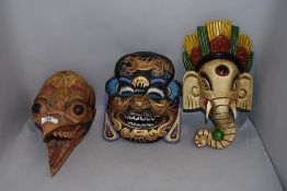 Three wooden hand carved tribal ethnic or ritual masks including a Hindu Ganesh
