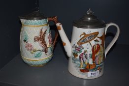 An antique French Majolica water jug having bird design with pewter lid and a similar late Victorian