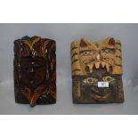 Two hand carved wooden ethnic tribal or ritual masks possibly native American