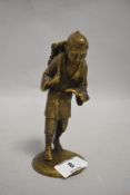 A Chinese Meiji period bronze figure of a wandering scholar or monk reading text book 14cm tall