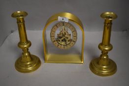 A pair of telescopic candle sticks with a modern brass cased skeleton clock