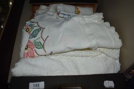 An assortment of vintage table linen including embroidered examples and items with crotchet edge.