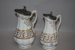 A pair of antique water jugs having pewter lids with Greek key design and ivy leaf pattern