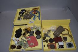 A selection of curios and trinkets including medals, jewellery and Monopoly pieces