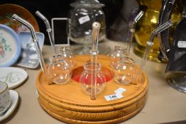 A pine tray having glass vessels with integrated straws.