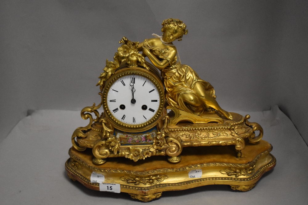 An 19th century French Empire garniture clock having ormolu case with porcelain panels and figure of