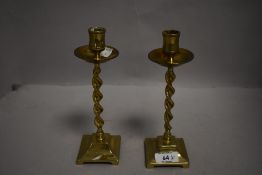 A pair of Victorian brass candlestick holders having barely twist columns.