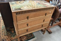 An early to mid 20th Century oak chest of three drawers on twist legs, with faux mosaic style