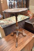 A late 19th or early 20th Century oak wine table having turned column and triple splay legs,