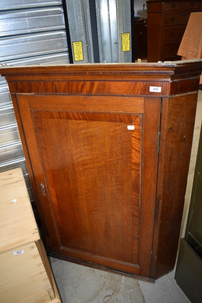 A 19th Century oak corner cupboard having mahogany cross banding