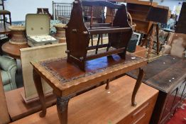 A stained frame coffee table having carved vine decoration and a mahogany effect magazine rack