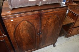 A 19th Century mahogany side cabinet having gothic style panelled doors and claw feet, width approx.