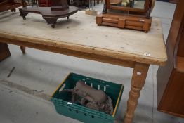 A large modern pine farmhouse kitchen table, of rounded rectangular form with turned supports.