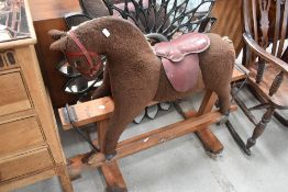 A vintage rocking horse, plush style on wood frame