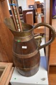 A vintage oak and brass jug and quantity of walking sticks