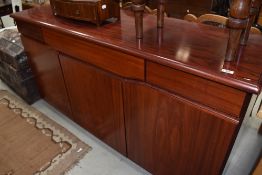 A modern stained walnut sideboard, the oblong figured top above three frieze drawers and three