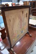 A mahogany framed embroidered fire screen