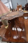 A mid 20th Century table having folding frame currently screwed to carved top