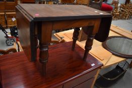 A mahogany sofa table, the oblong top with hinged rounded flaps above an associated base with turned