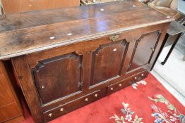 A period oak kist having lift lid and panelled door access via front, with double drawers to base,