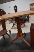 A 19th century mahogany stem table, with rounded rectangular top above a turned column issuing three