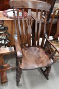 A traditional stained frame rocking chair, over stained and in some disrepair