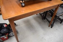 A mid century oak extending dining table, of plain rectangular form with tapering square legs