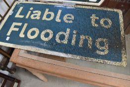 A metal road sign 'Liable to flooding'